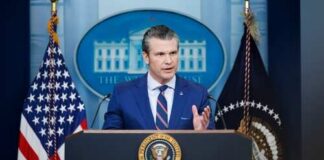 Government official speaking at a podium in the White House press briefing room