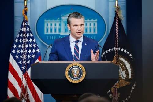 Government official speaking at a podium in the White House press briefing room