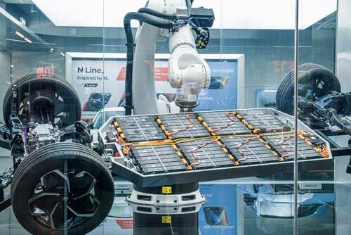 Robotic arm assembling an electric vehicle battery in a display