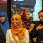 Is Omar’s Father A War Criminal? A group of women in cultural attire smiling at an event