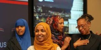 A group of women in cultural attire smiling at an event