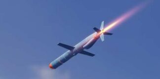 A missile in flight with a trail of smoke and flames