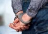 Person with hands handcuffed behind their back