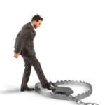 A man in a suit stepping towards a large bear trap