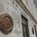 Exterior view of the Department of the Treasury building with a bronze plaque