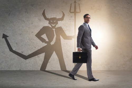 Businessman walking with a briefcase, shadow depicting a devil figure