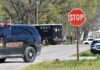 Deadly Confrontation: Shooter’s Last Act A sheriff's vehicle and a SWAT truck near a stop sign on a road