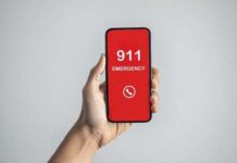 Hand holding a smartphone displaying an emergency call screen