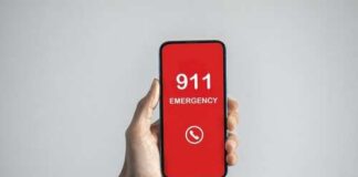 Hand holding a smartphone displaying an emergency call screen