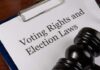 A clipboard with a document titled 'Voting Rights and Election Laws' next to a gavel
