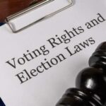 A clipboard with a document titled 'Voting Rights and Election Laws' next to a gavel