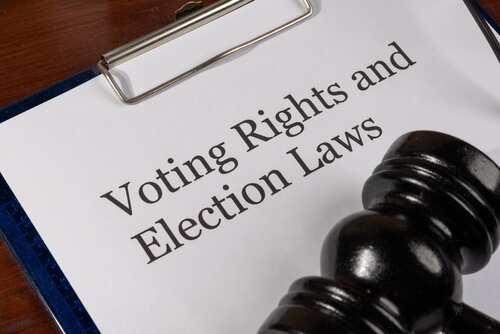 A clipboard with a document titled 'Voting Rights and Election Laws' next to a gavel