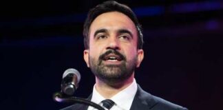 Man in a suit speaking at a podium with a microphone