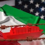 A red cargo ship on a background of Iranian and American flags with barbed wire
