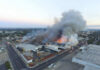 Chemical Implosion Turns Deadly: Workers Feared Missing A large industrial fire with thick smoke rising into the sky and firefighters responding