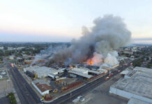 Chemical Implosion Turns Deadly: Workers Feared Missing A large industrial fire with thick smoke rising into the sky and firefighters responding