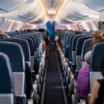 Airplane cabin interior with passengers seated inside