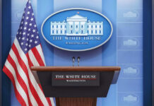 Podium with microphones in front of American flag