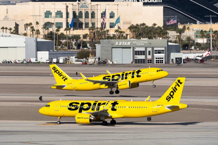 2439227217 Two yellow Spirit Airlines planes on airport taxiway.