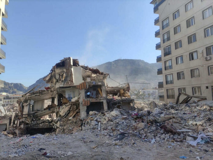 2503713475 Collapsed building surrounded by debris and mountains