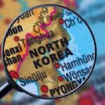 A magnifying glass focusing on the North Korea section of a map