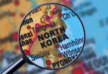 Kim’s Nuclear Retaliation Clause Explodes Tensions A magnifying glass focusing on the North Korea section of a map