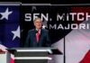 Mystery Hospital Stay Shadows McConnell Man speaking at podium with flag background