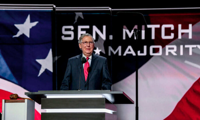 1569591907 Man speaking at podium with flag background