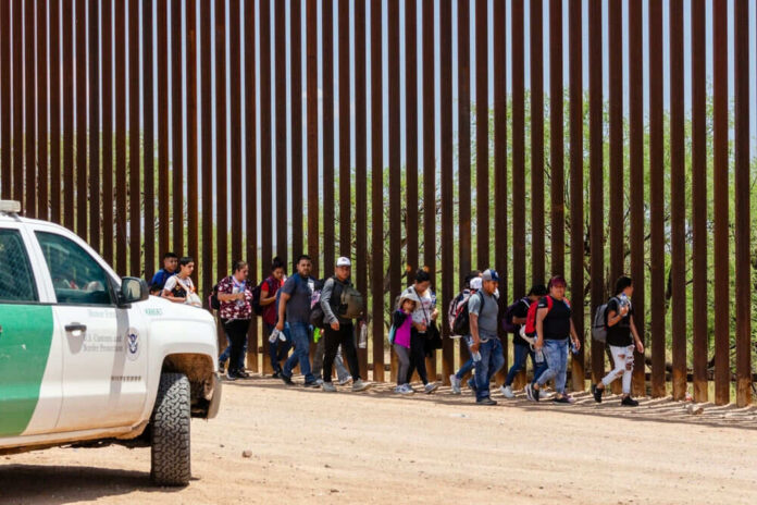 2333258557-1 Border Patrol vehicle near group of people walking