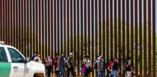 Border Patrol vehicle near group of people walking