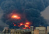 Large industrial fire with thick black smoke and flames