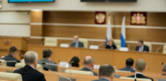 Audience attending a government meeting in a conference room