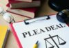 BOLTON BUSTED: Classified Cache Exposed Document titled 'PLEA DEAL' with a gavel and legal books in the background