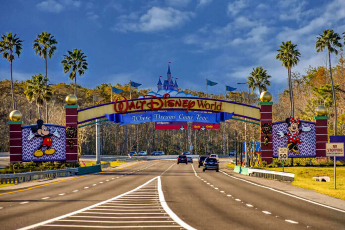 Walt Disney World entrance road with archway and characters.