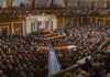 People in a large government assembly hall meeting