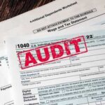 Tax forms with an 'AUDIT' stamp prominently displayed