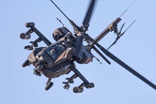 Apache,Military,Helicopter,In,Action An Apache helicopter flying in the sky with visible rotor blades