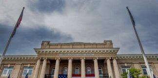 Historic building with large American flag and multiple flags in front
