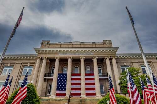 Memorial,Day,Tribute,At,The,Smyth,County,Courthouse,In,Virginia Historic building with large American flag and multiple flags in front
