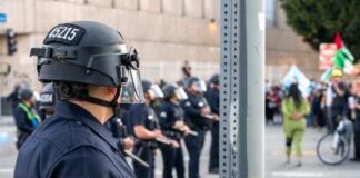 Police officers in riot gear monitoring a protest