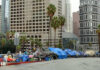 Street lined with tents and makeshift shelters downtown.