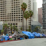 High-Traffic Hotspots Reopened — Buckle Up Street lined with tents and makeshift shelters downtown.