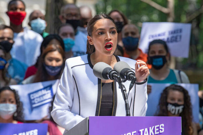 Person speaking at a public event with crowd.