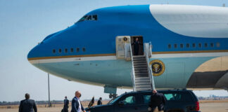 Airplane with stairs and people on the tarmac