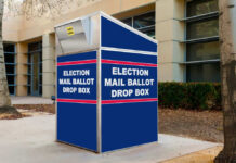 Blue election mail ballot drop box outside building.