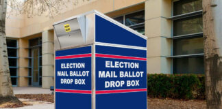 Blue election mail ballot drop box outside building.