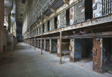 Triple Execution Shock — Same Day Interior view of an abandoned prison with empty cells and peeling paint