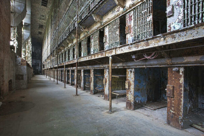 215362786 Interior view of an abandoned prison with empty cells and peeling paint