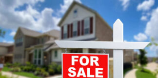 For sale sign in front of house