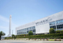SpaceX building with rocket and palm tree outside